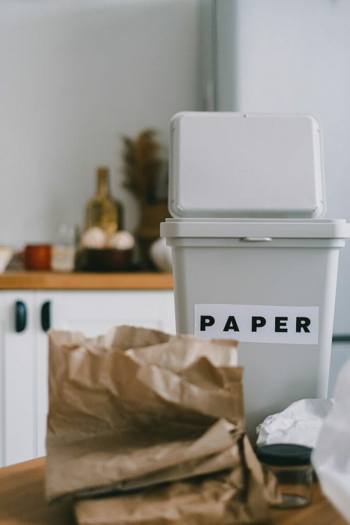 Folded crumpled paper near bin on table